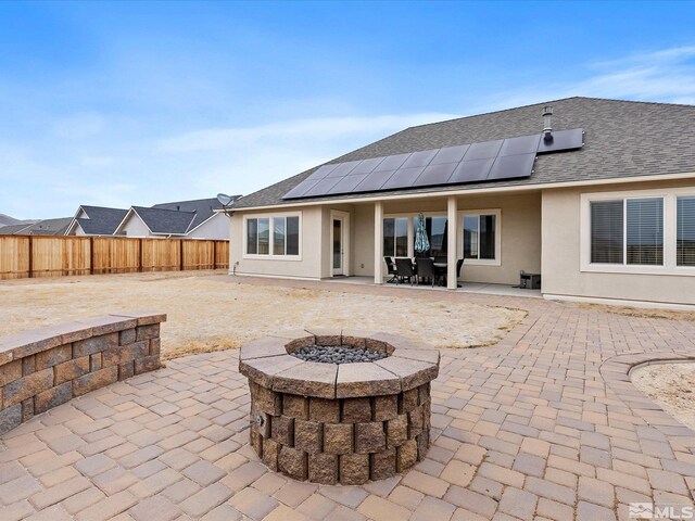 11641 Vista Park Dr, Sparks, NV 89441 - rear view of house with stucco siding, a fire pit, a patio area, a fenced backyard, and roof with shingles