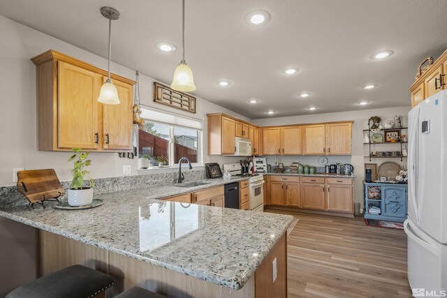 18190 Cody Ct, Reno, NV 89508 - kitchen featuring white appliances, a peninsula, a sink, recessed lighting, and light stone countertops