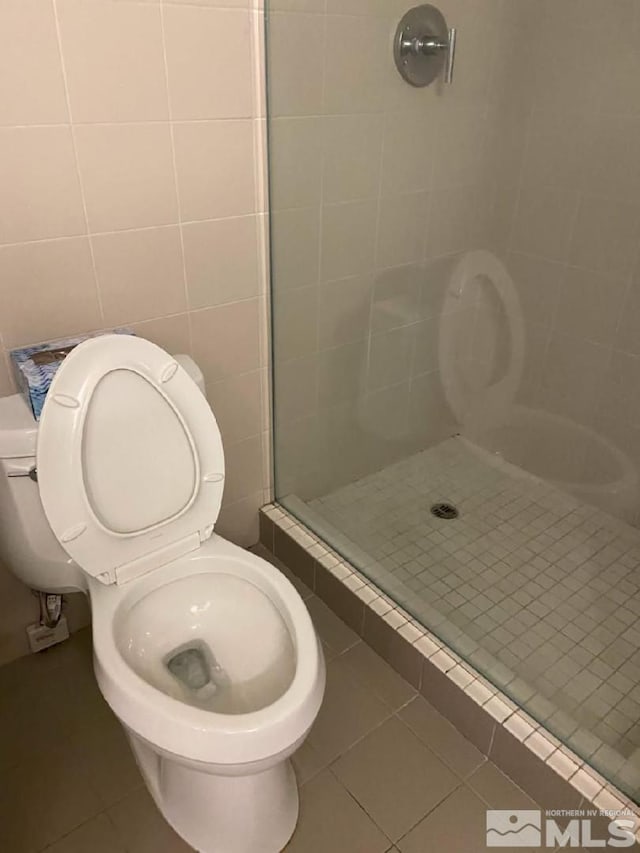 255 N Sierra St Unit 1709, Reno, NV 89501 - full bath with tile patterned flooring, a shower stall, tile walls, and toilet