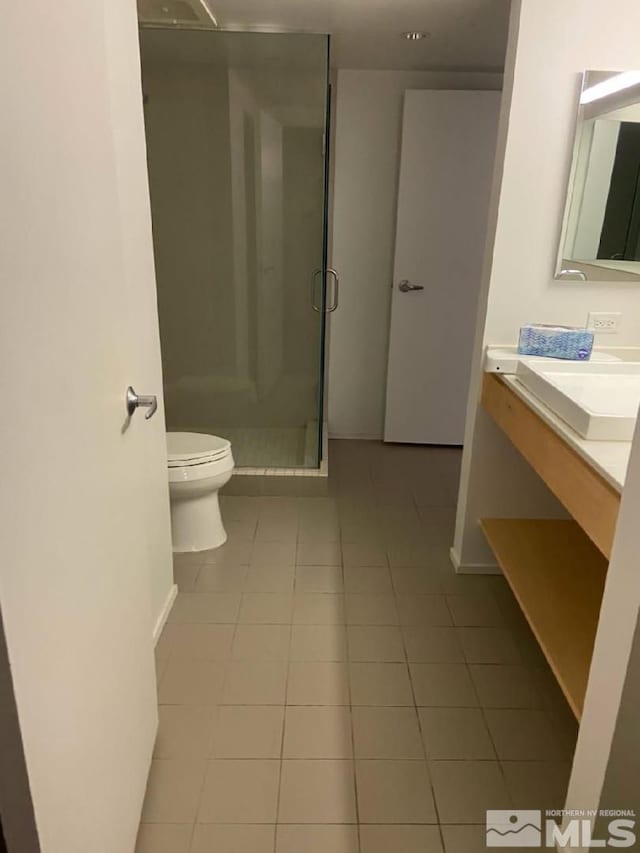 255 N Sierra St Unit 1709, Reno, NV 89501 - bathroom featuring tile patterned flooring, a stall shower, baseboards, toilet, and vanity