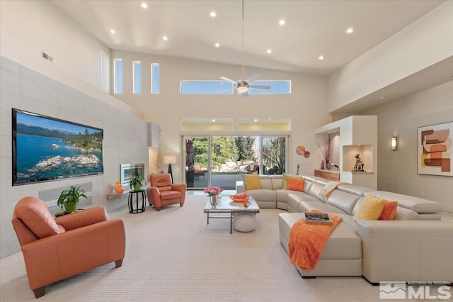 living area featuring a high ceiling, ceiling fan, recessed lighting, and light colored carpet