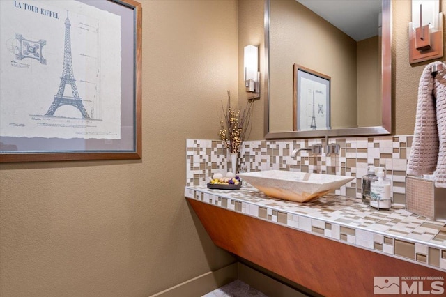 bathroom featuring backsplash, vanity, and baseboards