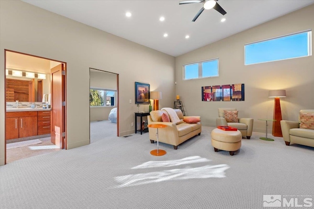 living area featuring light carpet, recessed lighting, a high ceiling, ceiling fan, and baseboards