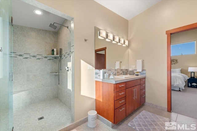 full bathroom featuring tiled shower, baseboards, connected bathroom, and tile patterned flooring
