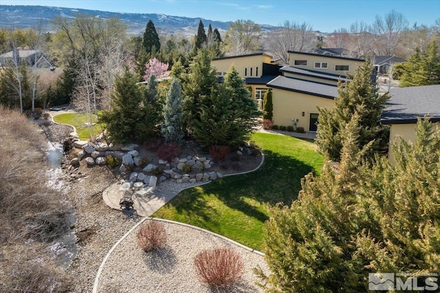 view of green lawn featuring a mountain view