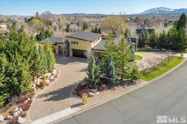 view of front of home with driveway, stucco siding, and a mountain view