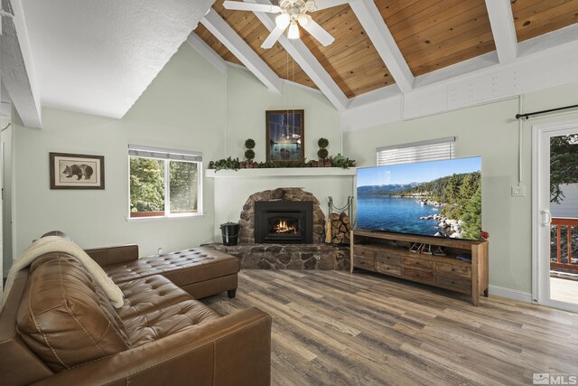 1348 Tirol Dr, Incline Village, NV 89451 - living room featuring beam ceiling, wood finished floors, a stone fireplace, a ceiling fan, and plenty of natural light