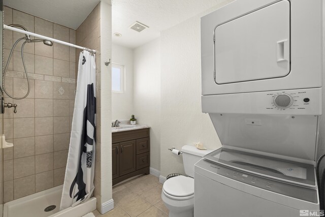 1348 Tirol Dr, Incline Village, NV 89451 - full bathroom featuring stacked washer and clothes dryer, tile patterned floors, a stall shower, vanity, and toilet