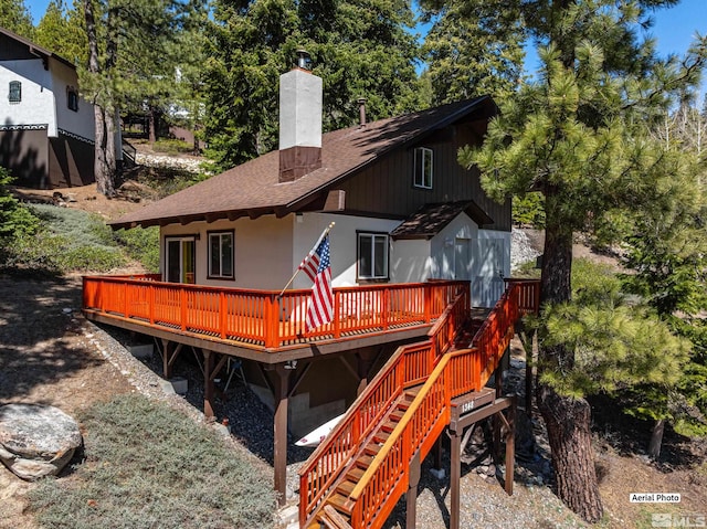 1348 Tirol Dr, Incline Village, NV 89451 - rear view of property with a deck, roof with shingles, a chimney, stairs, and view of wooded area