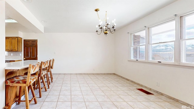unfurnished dining area with plenty of natural light, a chandelier, and baseboards