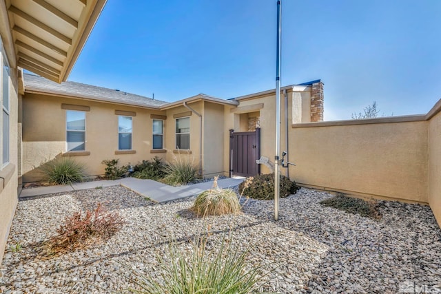 696 Raptor Way, Fernley, NV 89408 - doorway to property with stucco siding, a gate, and fence
