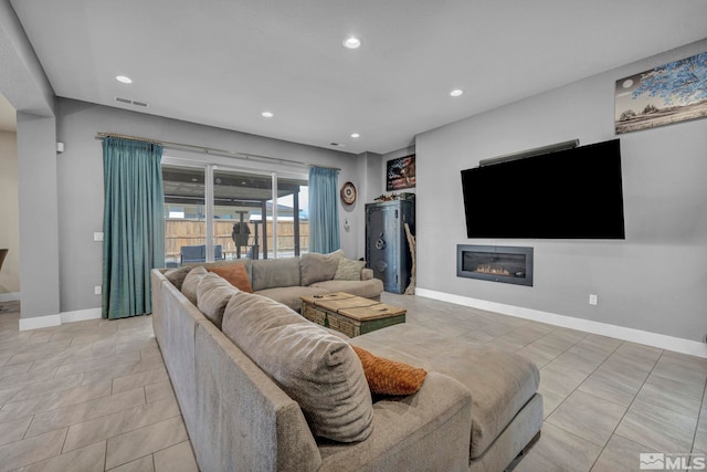 696 Raptor Way, Fernley, NV 89408 - living room with recessed lighting, baseboards, a glass covered fireplace, and light tile patterned floors