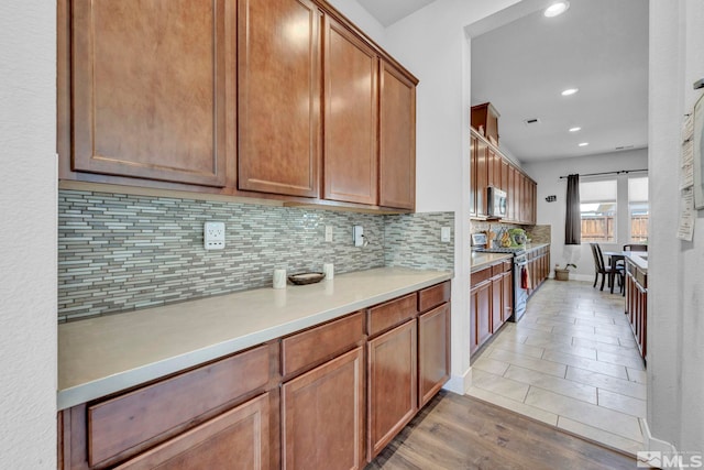 696 Raptor Way, Fernley, NV 89408 - kitchen with appliances with stainless steel finishes, backsplash, light countertops, recessed lighting, and brown cabinetry