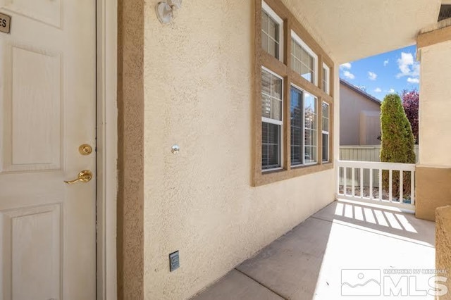 view of side of home featuring stucco siding and a porch