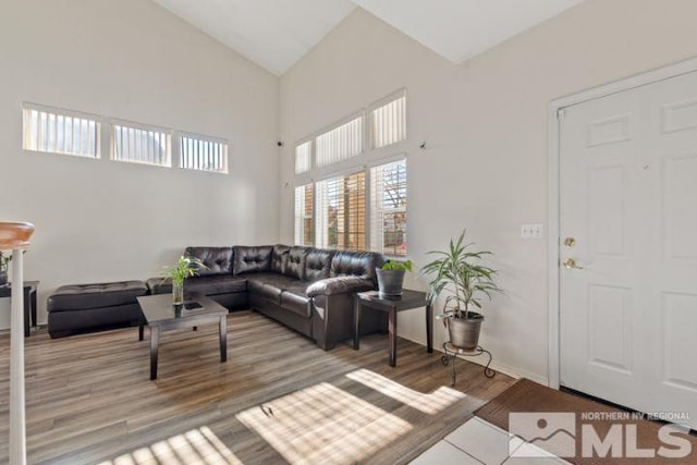 living area with high vaulted ceiling and wood finished floors