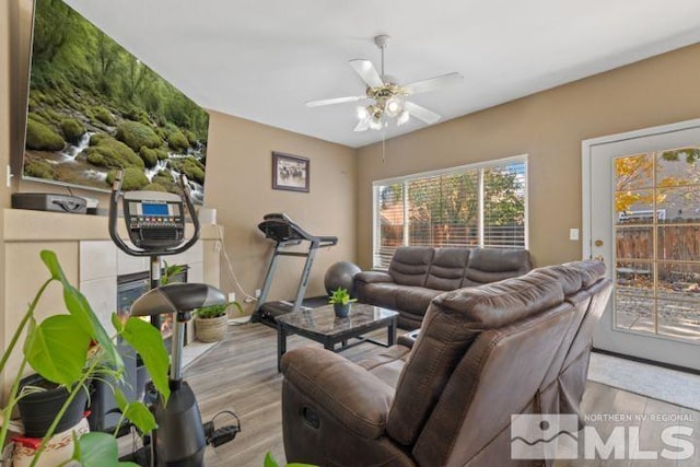 living area with wood finished floors and a ceiling fan