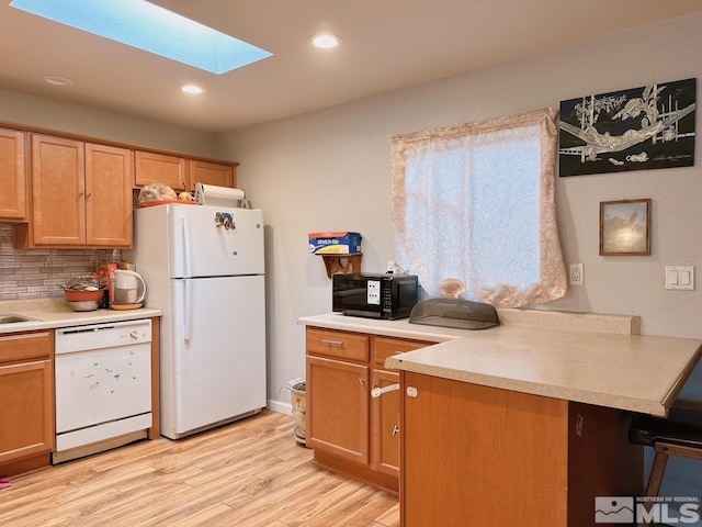 695 York Way, Sparks, NV 89431 - kitchen with white appliances, a skylight, light wood-style flooring, decorative backsplash, and light countertops
