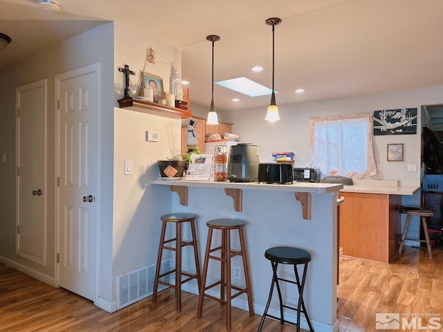 695 York Way, Sparks, NV 89431 - kitchen with light wood finished floors, a breakfast bar area, and a peninsula