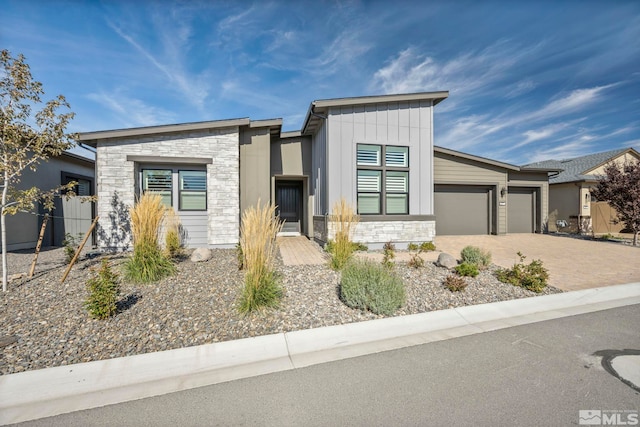 2277 White Clay Dr, Reno, NV 89521 - contemporary home featuring stone siding, a garage, driveway, and board and batten siding