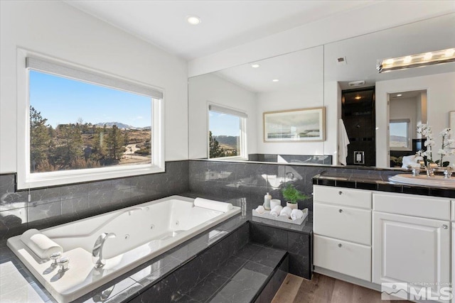 10241 Zuni Ridge Trl, Reno, NV 89511 - full bath with vanity, a whirlpool tub, wood finished floors, and recessed lighting