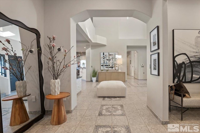 10241 Zuni Ridge Trl, Reno, NV 89511 - foyer with arched walkways, a towering ceiling, and baseboards