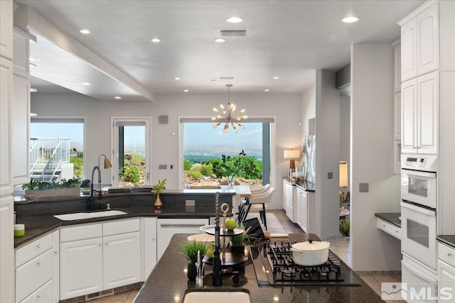 10241 Zuni Ridge Trl, Reno, NV 89511 - kitchen featuring a sink, white appliances, a chandelier, white cabinets, and recessed lighting