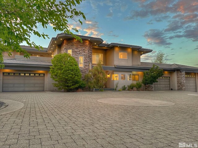 10241 Zuni Ridge Trl, Reno, NV 89511 - view of front of home featuring stone siding, curved driveway, and stucco siding