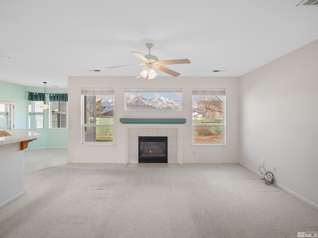 2976 Del Rio Ln, Minden, NV 89423 - unfurnished living room with carpet, a tiled fireplace, baseboards, and a ceiling fan