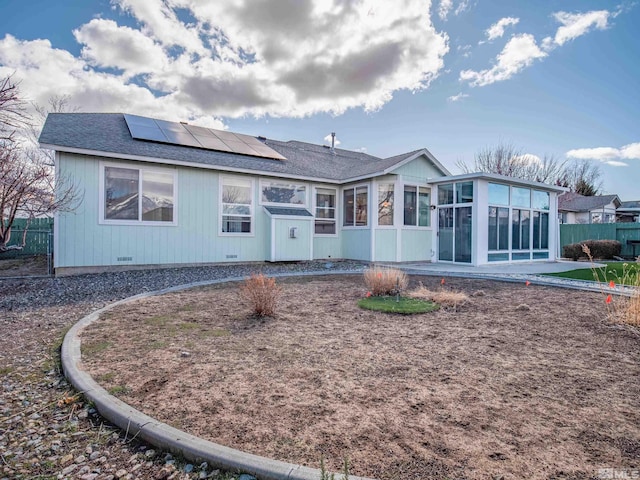 2976 Del Rio Ln, Minden, NV 89423 - rear view of house featuring a sunroom, roof mounted solar panels, fence, and roof with shingles