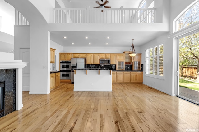 6841 Talmedge Cir, Sparks, NV 89436 - kitchen with a high ceiling, appliances with stainless steel finishes, a breakfast bar, light wood-style flooring, and ceiling fan