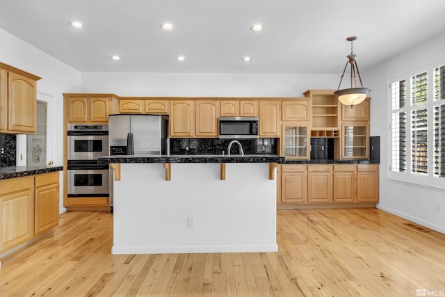 6841 Talmedge Cir, Sparks, NV 89436 - kitchen with appliances with stainless steel finishes, a kitchen breakfast bar, tasteful backsplash, recessed lighting, and light wood-type flooring