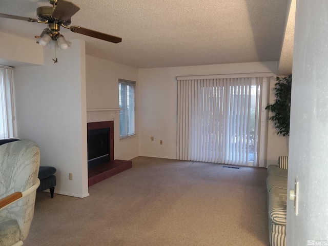 2341 Roundhouse Rd, Sparks, NV 89431 - unfurnished living room featuring carpet flooring, a fireplace with raised hearth, ceiling fan, and a textured ceiling