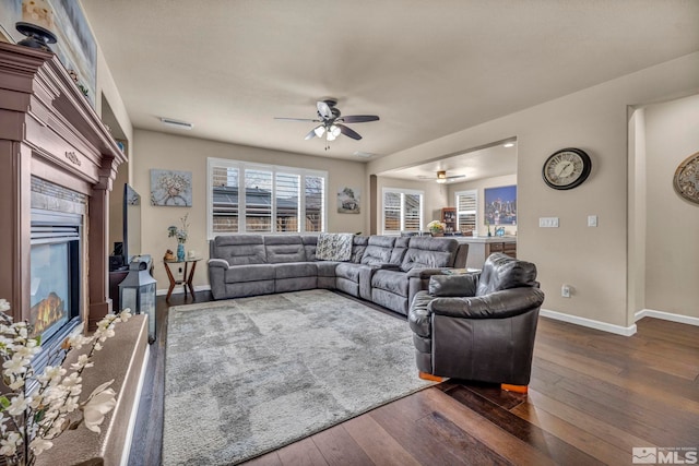 132 Egan Ave, Dayton, NV 89403 - living room featuring ceiling fan, a glass covered fireplace, dark wood finished floors, and baseboards