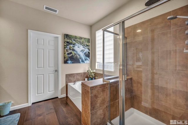 132 Egan Ave, Dayton, NV 89403 - full bathroom featuring wood finished floors, a shower stall, a bath, and baseboards