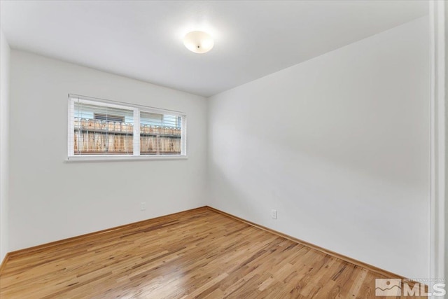 spare room featuring light wood-style flooring and baseboards