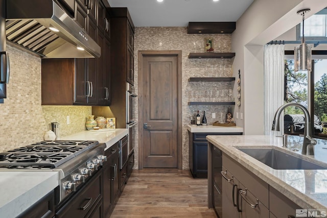 20588 Chanson Way, Reno, NV 89511 - kitchen with under cabinet range hood, stainless steel gas cooktop, a sink, decorative backsplash, and light wood-style flooring
