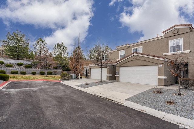 5625 Vista Luna Dr Unit 102, Sparks, NV 89436 - view of front of house with stucco siding, driveway, a tiled roof, and a garage