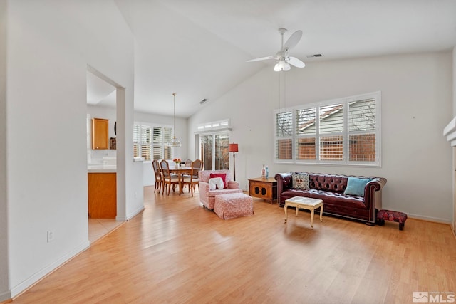 1676 Iron Mountain Dr, Reno, NV 89521 - living room with a ceiling fan, light wood-style floors, high vaulted ceiling, a chandelier, and baseboards