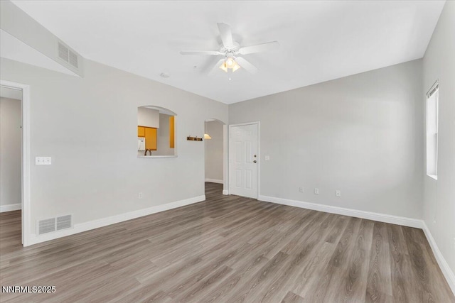 6850 Sharlands Ave Unit U1122, Reno, NV 89523 - empty room with ceiling fan, arched walkways, light wood finished floors, and baseboards
