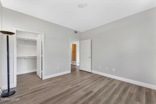 6850 Sharlands Ave Unit U1122, Reno, NV 89523 - unfurnished bedroom with wood finished floors, baseboards, a spacious closet, and a closet