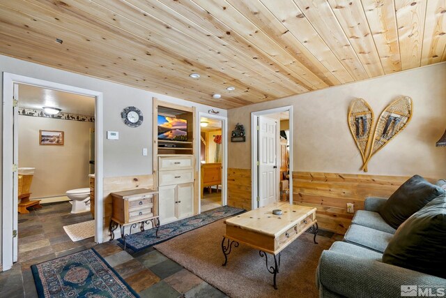 114 Angora Ct Unit A, Zephyr Cove, NV 89448 - living room featuring wood ceiling, a baseboard heating unit, stone finish floors, wood walls, and wainscoting