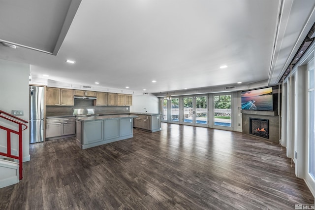 600 Island Ave, Reno, NV 89501 - kitchen featuring stainless steel fridge, open floor plan, a center island, dark wood finished floors, and a warm lit fireplace