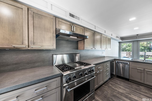600 Island Ave, Reno, NV 89501 - kitchen with appliances with stainless steel finishes, under cabinet range hood, a sink, dark countertops, and dark wood-type flooring
