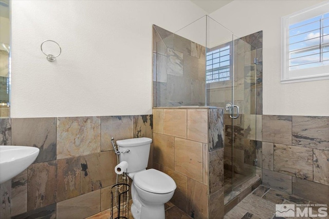 6131 Axis Dr, Sparks, NV 89436 - bathroom with tile walls, a shower stall, toilet, and a wainscoted wall