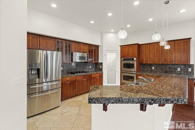 6131 Axis Dr, Sparks, NV 89436 - kitchen with appliances with stainless steel finishes, a sink, a kitchen breakfast bar, backsplash, and glass insert cabinets