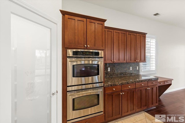 6131 Axis Dr, Sparks, NV 89436 - kitchen with double oven, backsplash, baseboards, and brown cabinets