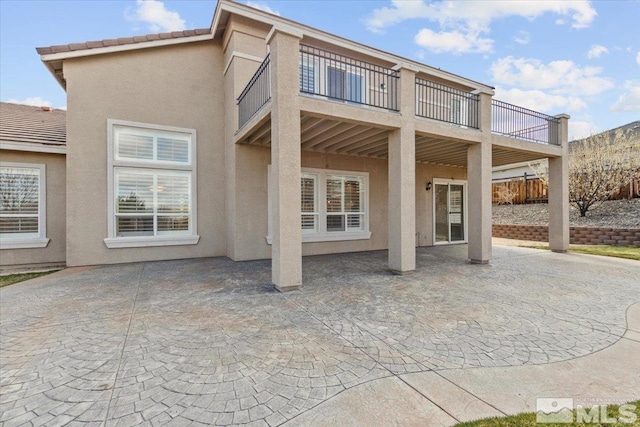 6131 Axis Dr, Sparks, NV 89436 - back of house featuring stucco siding, a balcony, and a patio