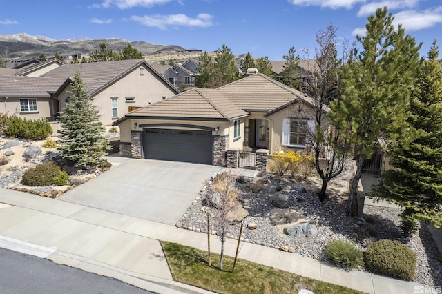 ranch-style house with an attached garage, stucco siding, concrete driveway, stone siding, and a tiled roof