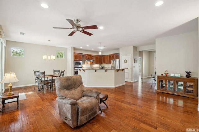 living area featuring a ceiling fan, a chandelier, recessed lighting, dark wood-style flooring, and baseboards