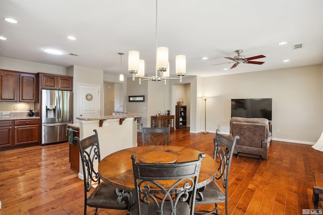 dining room featuring recessed lighting, ceiling fan, wood-type flooring, baseboards, and a chandelier